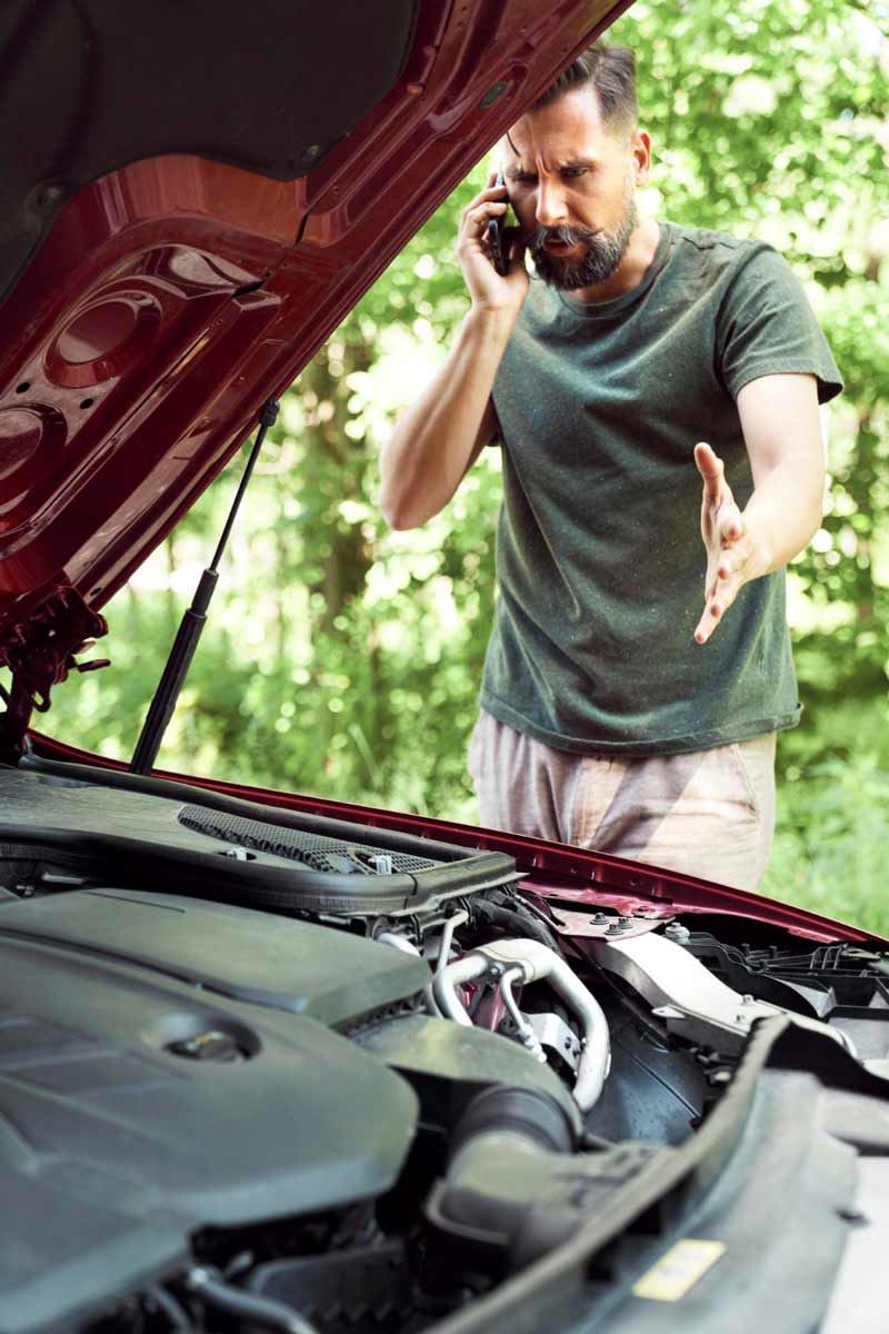 Junger Mann prüft Getriebeschaden bei Schrottauto Ankauf Lahnstein